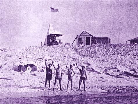 Some of the Jarvis Island colonists from the 1930s and their simple buildings behind them ...