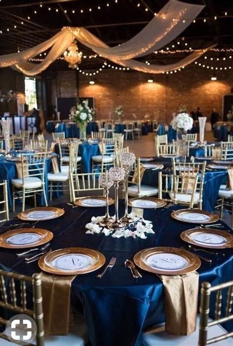 the tables are set up with blue and gold linens for an elegant wedding reception