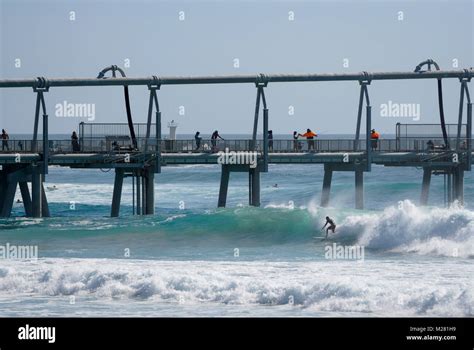 Surfing and fishing at The Spit, on the Gold Coast in Australia Stock ...