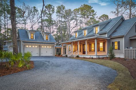 a large house with lots of windows in the front and side of it, surrounded by trees