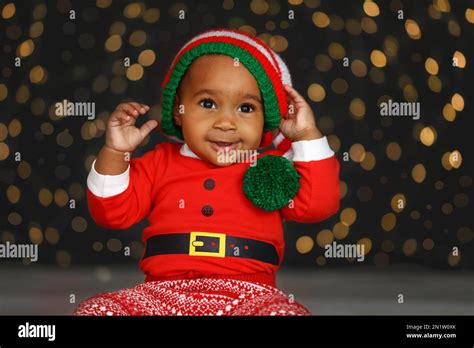 Cute little African American baby wearing elf hat against blurred ...