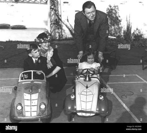 June Collyer, Stuart Erwin, pushing their children Stuart Jr. and Judy in kiddie cars, ca. 1940 ...