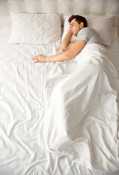 Man sleeping alone in bed - Stock Image - Everypixel