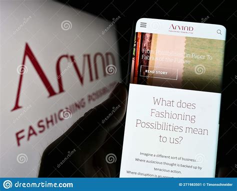 Person Holding Cellphone with Webpage of Indian Textile Company Arvind ...