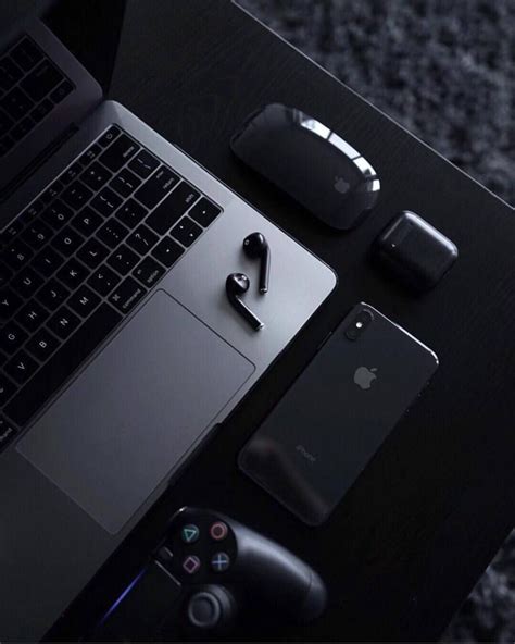 an open laptop computer sitting on top of a desk next to other ...