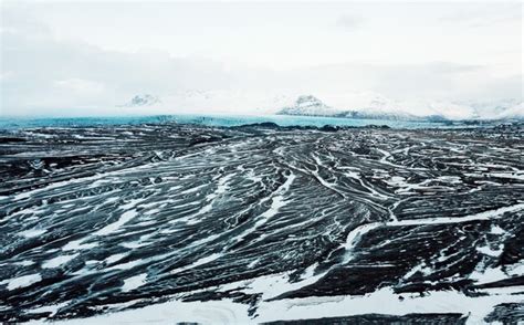 Premium Photo | Aerial view of the volcanic desert on iceland in the background a glacier black ...