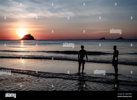 Sunset in Nacpan beach wih two persons ready for a bath Stock Photo - Alamy