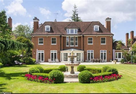 a large red brick house with a fountain in the middle of it's front yard