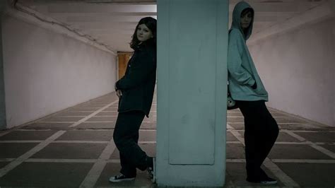 two people standing in an empty parking garage