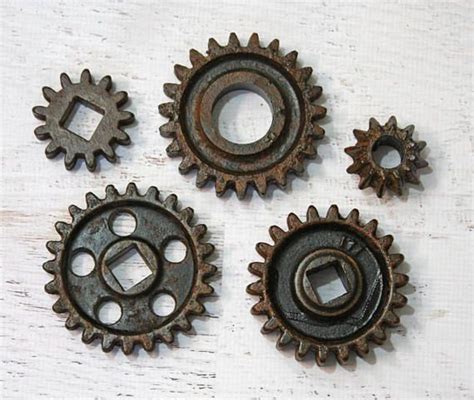 four rusty gears sitting on top of a white table