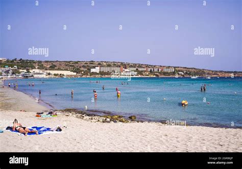 Malta: A woman sunbathes by the sea on the beach in Ghadira Bay Stock Photo - Alamy