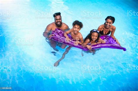 Portrait Of Africanamerican Family Floating On Pool Raft At Resort ...