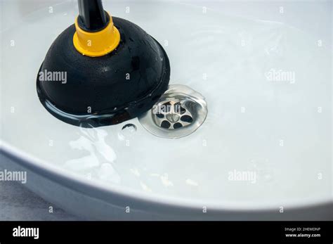 Concept of unclog blockages with a plunger. Clogged pipes and sink in the bathroom Stock Photo ...