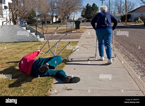 Two elderly senior citizens walk away using walkers, the woman tripped ...