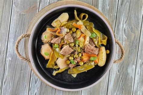 Premium Photo | Lamb stew with seasonal vegetables on black plate