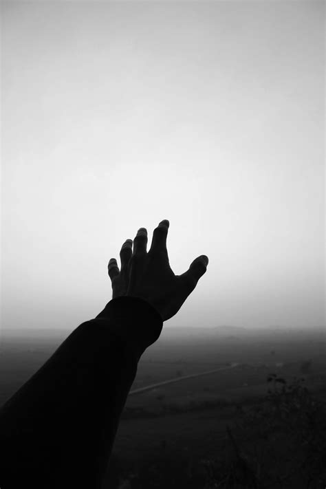 Grayscale Photo of Person's Hand Reaching For the Sky · Free Stock Photo