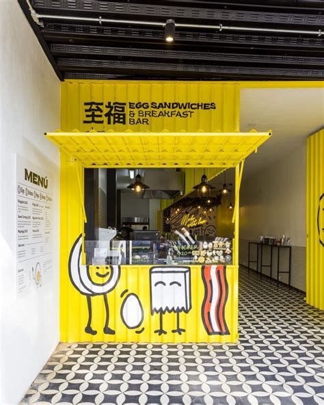 the interior of a restaurant with black and white tile flooring, yellow food stand