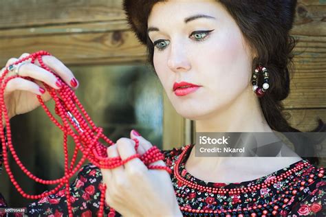 Russian Beauty Looking On Red Coral Beads In Raised Arms Stock Photo - Download Image Now - iStock