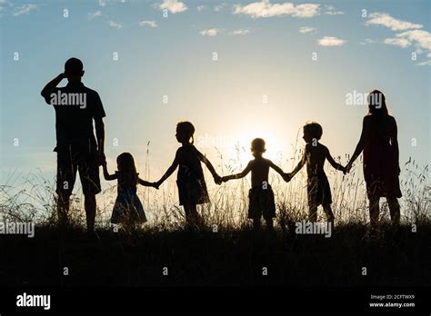 Silhouette of a happy large family at sunset Stock Photo - Alamy