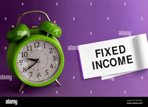 FIXED INCOME words in an office notebook purple background with a green table clock.Concept for ...