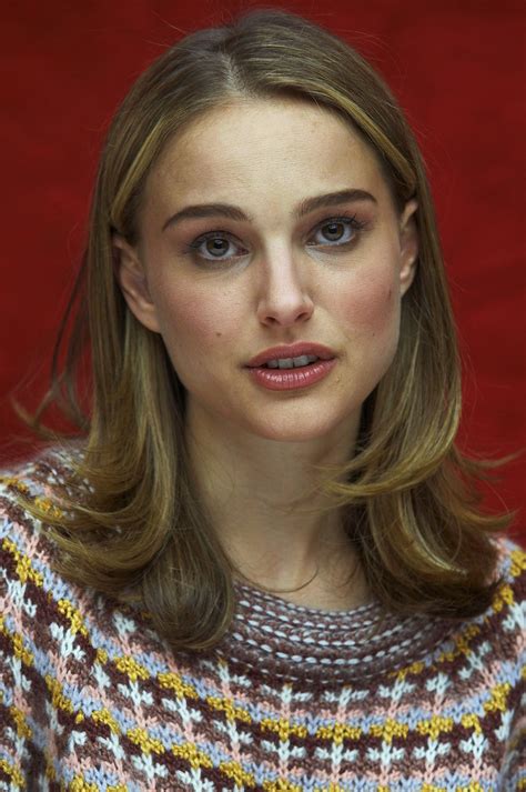 a woman with long brown hair and blue eyes wearing a multicolored ...