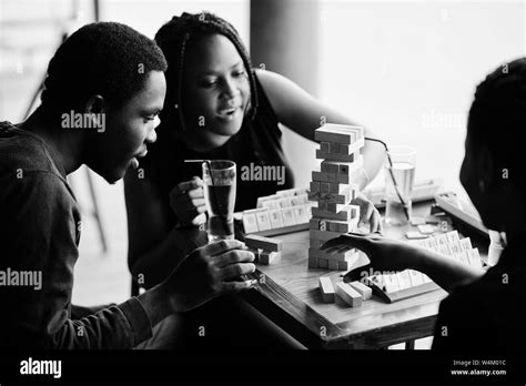 Group of three african american friends play table games Stock Photo - Alamy