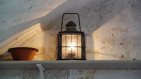 Black and Gray Metal Lantern on Brown Wooden Wall Shelf Near White ...