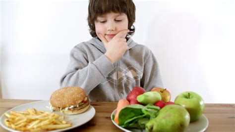 Young Boy Choosing Fast Food Instead Of Vegetables And Fruits Stock ...