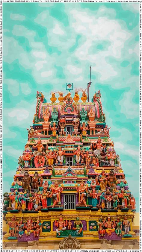 an elaborately decorated hindu temple with statues on the front and side walls, against a blue ...