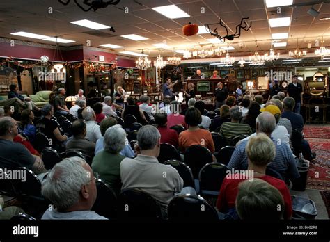 Antiques auction house with evening auction in progress Stock Photo - Alamy