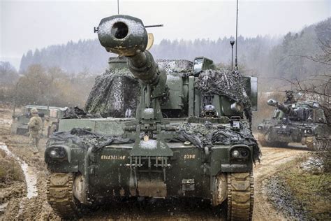 Soldiers maneuver an M109A6 Paladin howitzer to prepare for a live-fire ...