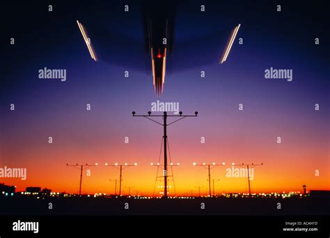 airliner landing over runway approach lights at night dusk sunset Stock ...