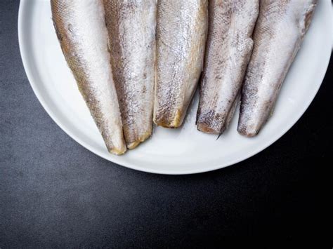 Premium Photo | Raw fish hake on white plate calcium rich fish