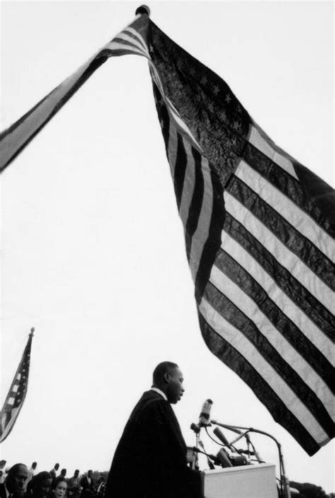 Martin Luther King Jr. under US flag (1957) - Photographic print for sale