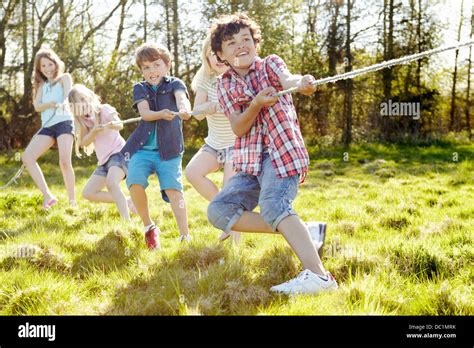 Group of young children playing tug o war Stock Photo - Alamy