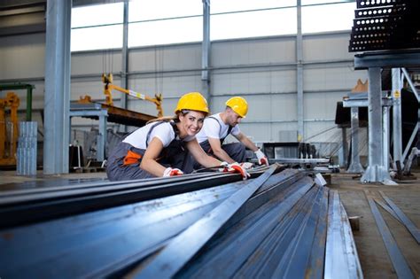 Free Photo | Industrial workers working in factory hall with metal