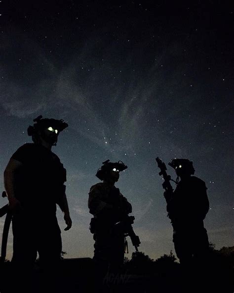 Silhouettes of Gas Masked Soldiers Under the Night Sky