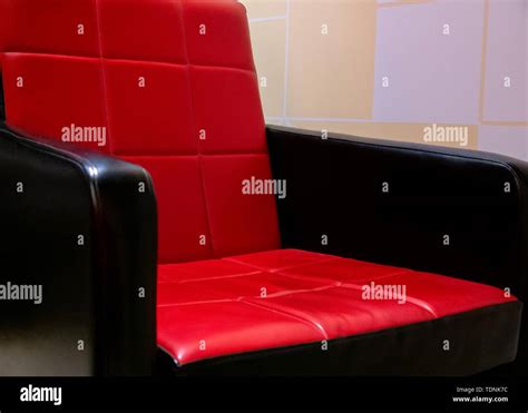 View on a retro red and black faux leather sofa in a room Stock Photo - Alamy