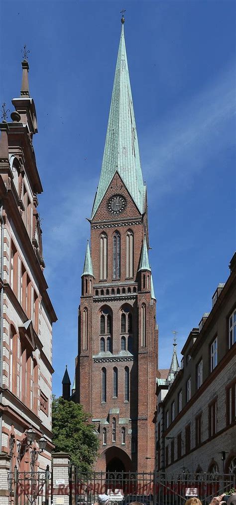 an old building with a steeple on top and people walking in the street ...