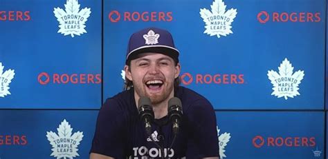 a man is laughing while sitting in front of a wall with the toronto ...