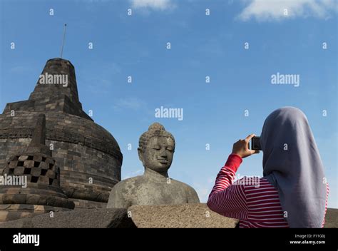 Tourist photographing Buddha statue on Temple of Borobudur, Borobudur, Indonesia Stock Photo - Alamy