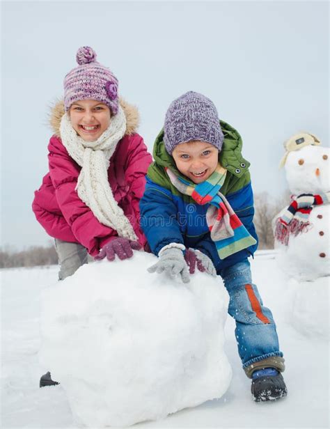 Kids make a snowman stock image. Image of gloves, holiday - 33374905