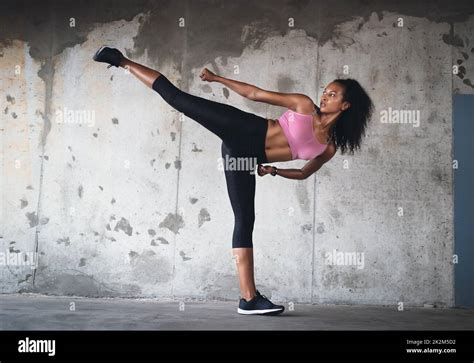 Balance is everything. Full length shot of a young sportswoman kicking ...