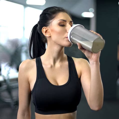 Sporty woman drinking protein shake after workout, muscle gain ...