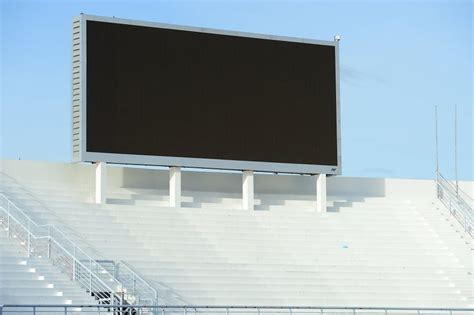 A blank stadium scoreboard screen above the stands in the day time en ...