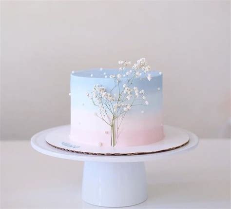 a white cake with blue and pink frosting decorated with flowers on a ...