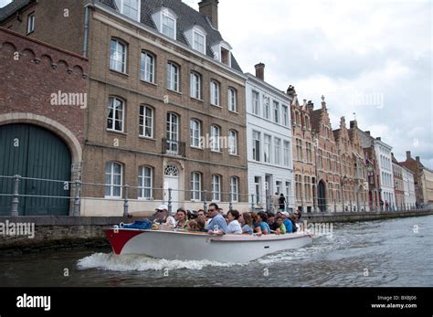 A canal cruise boat taking passengers on a tour of Bruges and its ...