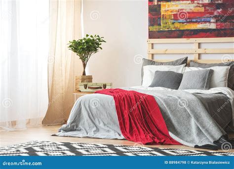 Grey bed with red blanket stock photo. Image of indoors - 88984798