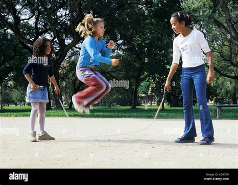 Children kids girls children jumping rope three standing holding mid Stock Photo: 2516952 - Alamy