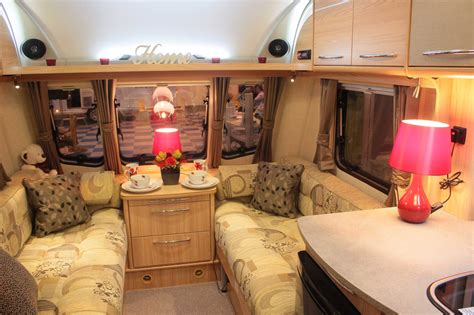 the inside of a motor home with couches, tables and lamps on it's sides